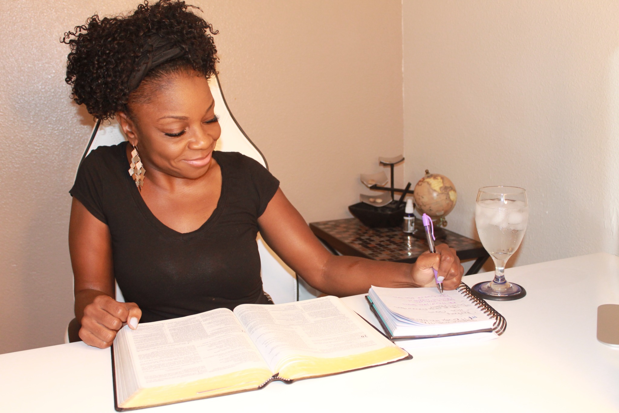 Mandy smiling as she studies the Bible and writes mentoring notes